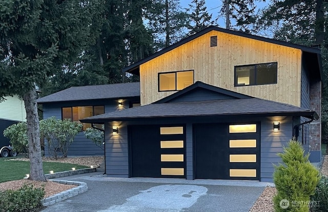 view of front of property with a garage and a shingled roof