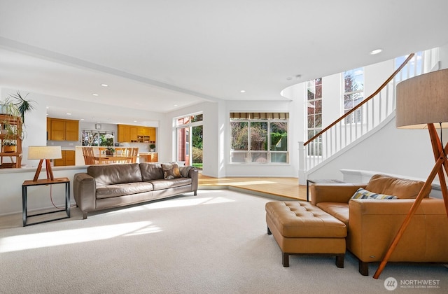 living area with light carpet, stairway, recessed lighting, and baseboards