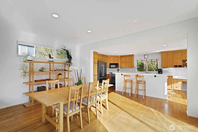 dining space featuring light wood-style flooring, recessed lighting, and baseboards