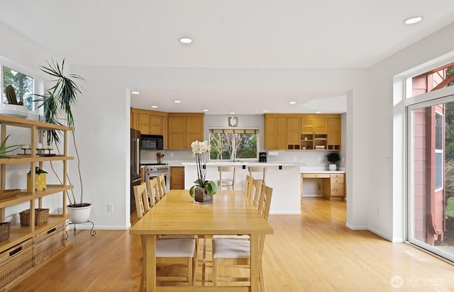 dining space with light wood finished floors, plenty of natural light, and recessed lighting