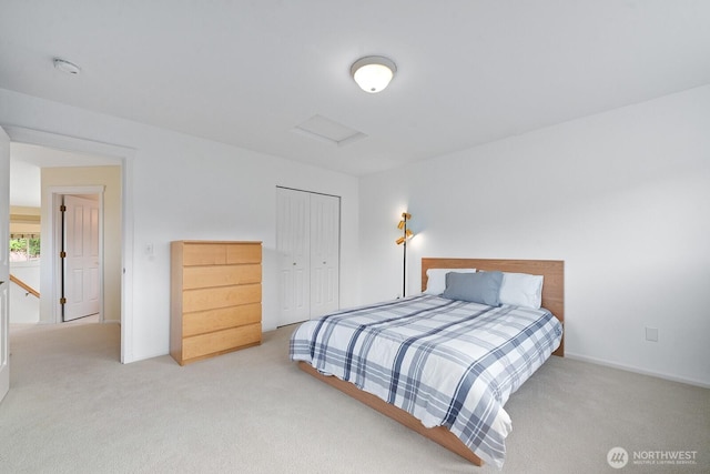 carpeted bedroom featuring attic access, baseboards, and a closet