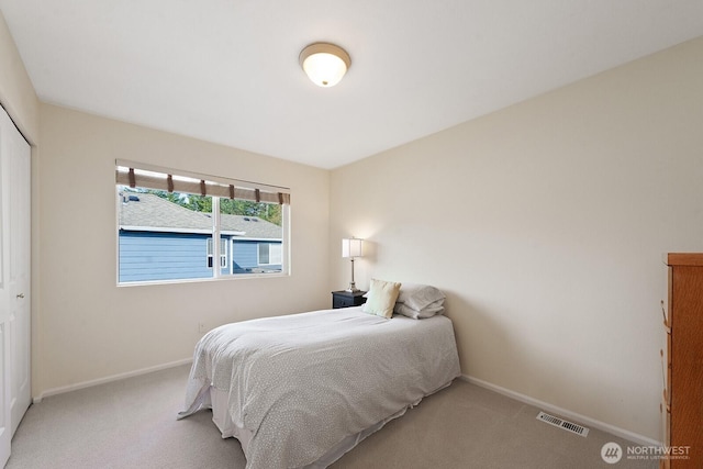 bedroom featuring a closet, visible vents, baseboards, and carpet