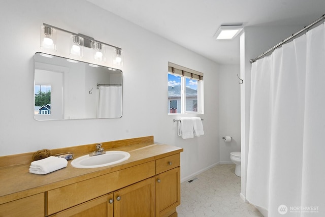 bathroom featuring visible vents, baseboards, toilet, and vanity