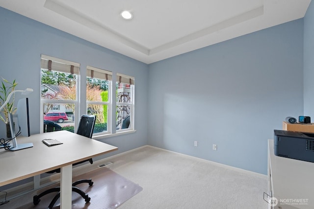 home office featuring baseboards, a tray ceiling, carpet floors, and visible vents