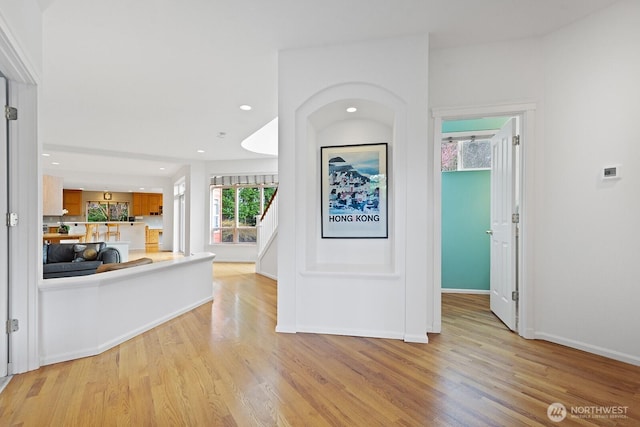 hallway featuring recessed lighting, light wood-style floors, and baseboards