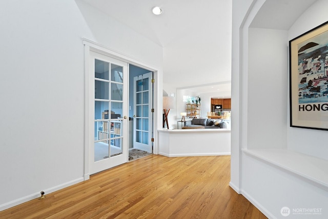 interior space featuring recessed lighting, french doors, baseboards, and wood finished floors