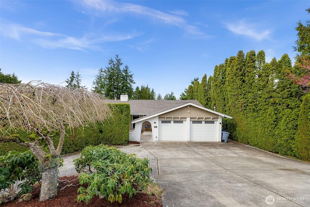 ranch-style house with an attached garage, driveway, and a chimney