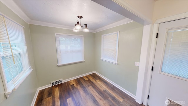 unfurnished dining area with dark wood finished floors, baseboards, visible vents, and ornamental molding