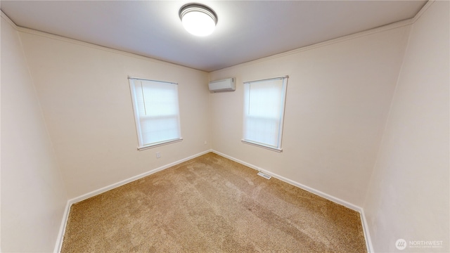 carpeted spare room featuring visible vents, a wall mounted AC, and baseboards