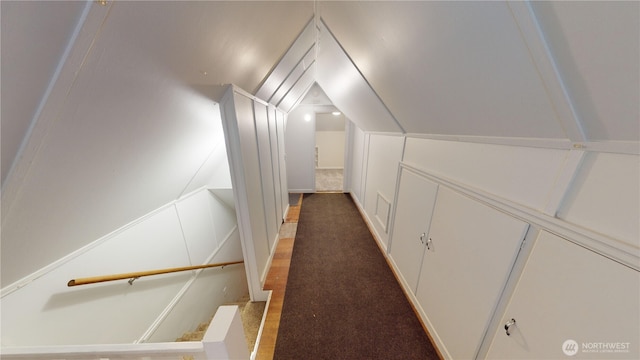 hallway featuring carpet flooring and lofted ceiling