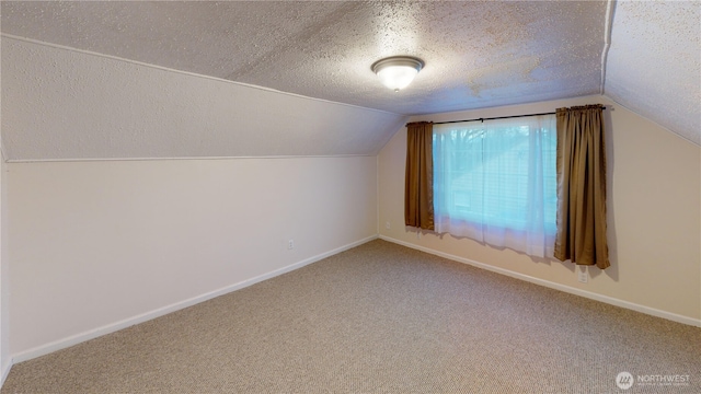 bonus room featuring a textured ceiling, lofted ceiling, baseboards, and carpet floors