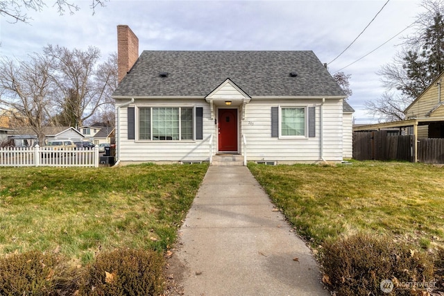 view of front of property with a front lawn, fence, roof with shingles, and a chimney