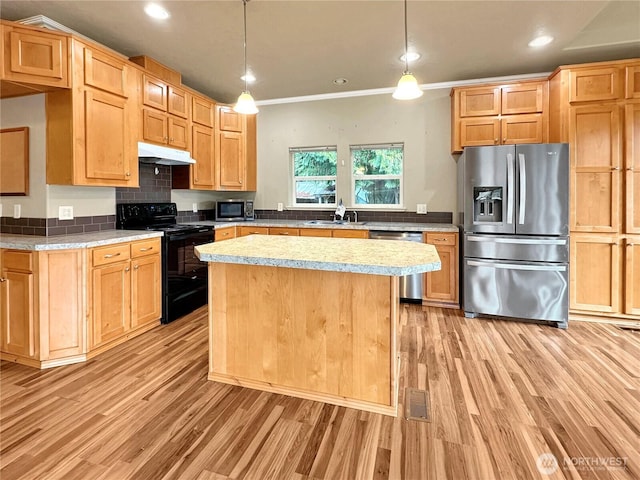 kitchen featuring under cabinet range hood, light countertops, light wood-type flooring, and appliances with stainless steel finishes