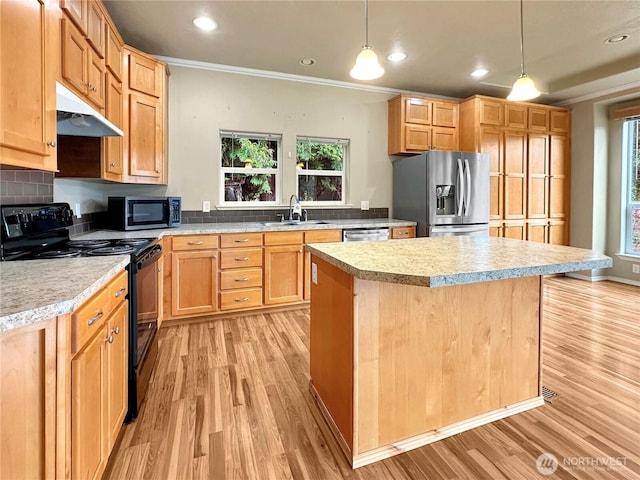 kitchen with a sink, stainless steel appliances, light countertops, light wood-style floors, and under cabinet range hood