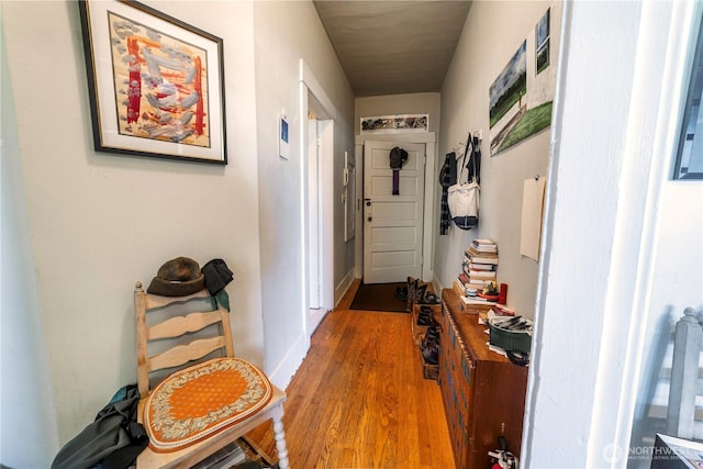 corridor with baseboards and wood finished floors