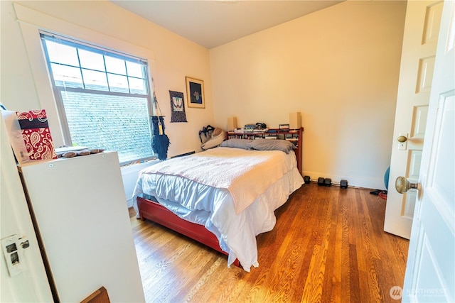 bedroom with baseboards and wood finished floors