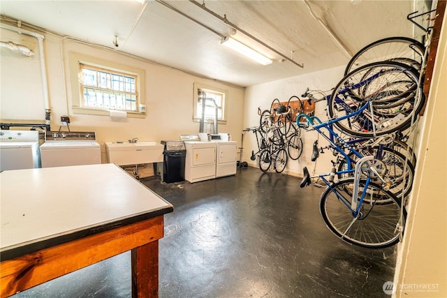 garage with bike storage, independent washer and dryer, and a sink