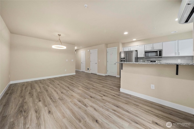 kitchen featuring white cabinets, light wood-style floors, baseboards, and appliances with stainless steel finishes