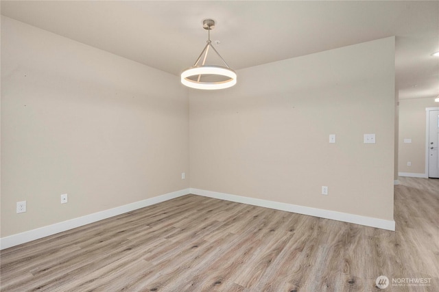 spare room with light wood-style floors and baseboards