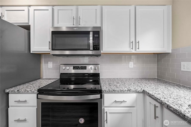 kitchen with white cabinetry, decorative backsplash, light stone counters, and appliances with stainless steel finishes