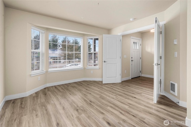 unfurnished room with visible vents, baseboards, and light wood-style flooring