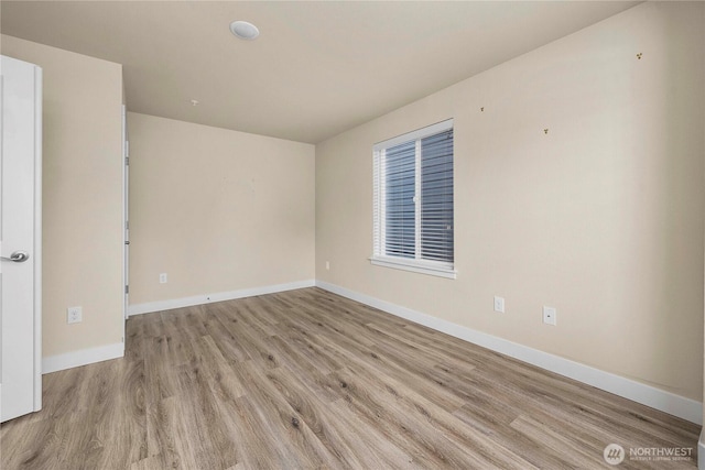 spare room featuring wood finished floors and baseboards