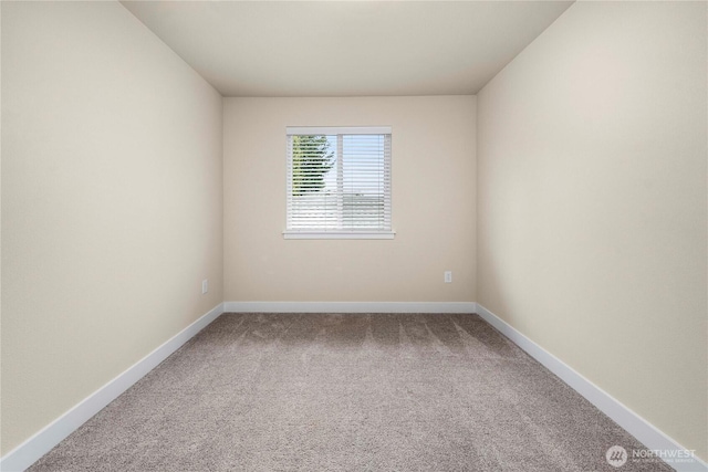 spare room with baseboards and carpet floors