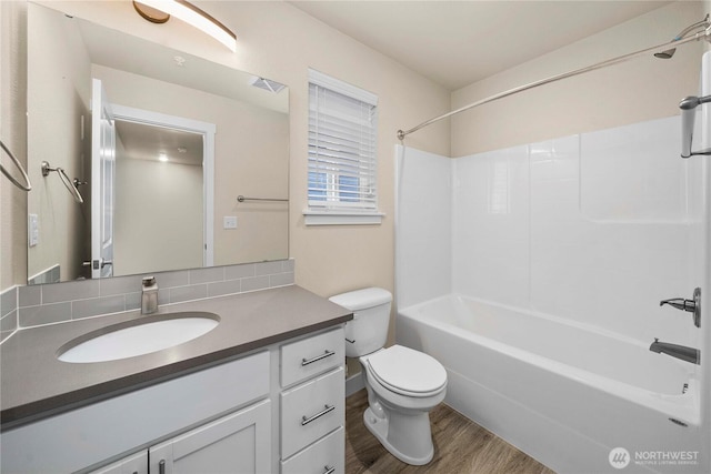 full bathroom featuring vanity, wood finished floors, visible vents, shower / tub combination, and toilet