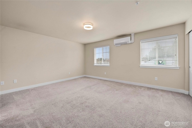 carpeted spare room featuring baseboards and a wall unit AC