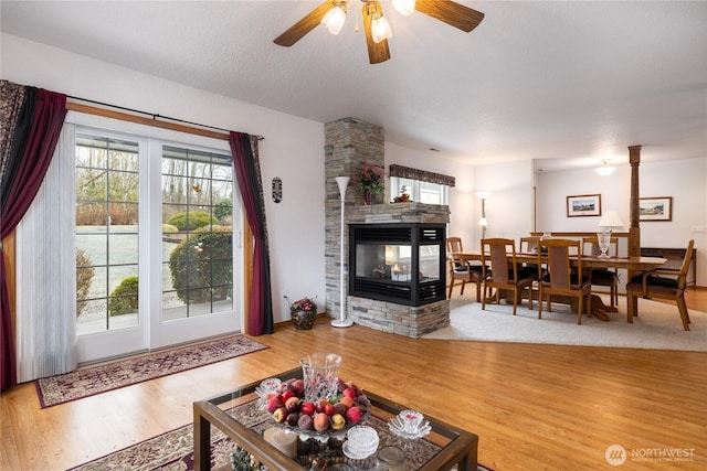 6084 Gartin Pl, Sedro Woolley, WA 98284 - living room with a multi sided fireplace, a textured ceiling, ceiling fan, and wood finished floors