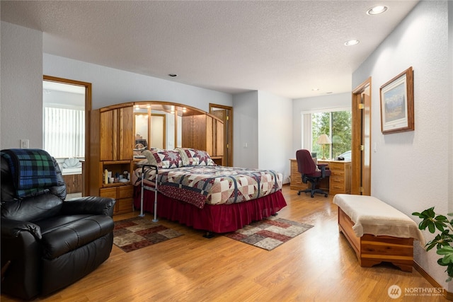 6084 Gartin Pl, Sedro Woolley, WA 98284 - bedroom with recessed lighting, arched walkways, light wood-style floors, and a textured ceiling