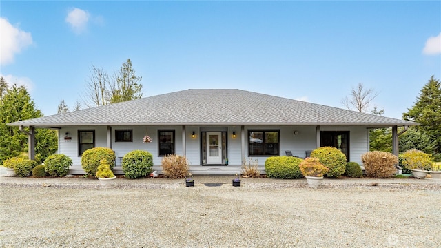 ranch-style house with a porch and roof with shingles