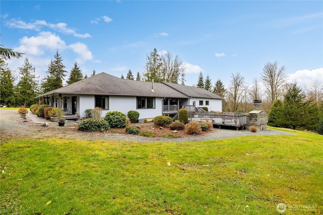 back of property featuring a lawn and a deck