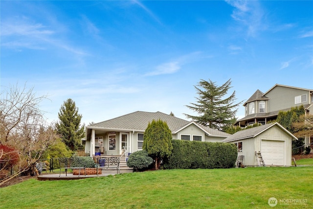 view of front facade with fence, a porch, a front lawn, an outdoor structure, and a detached garage