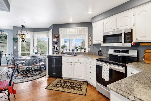 kitchen with light wood finished floors, recessed lighting, appliances with stainless steel finishes, white cabinetry, and a sink