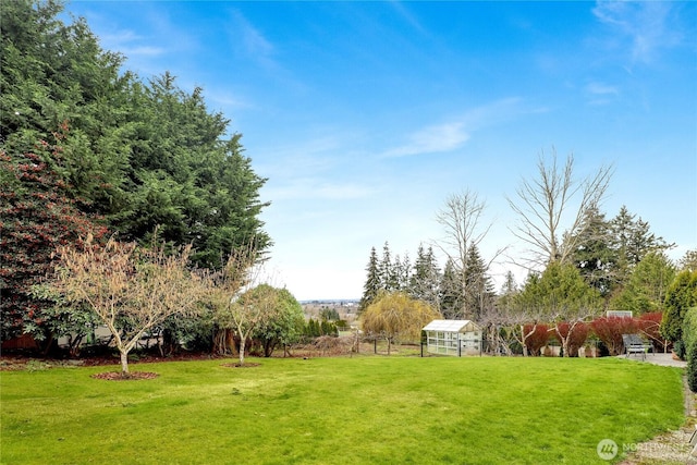 view of home's community with a yard, an outbuilding, and fence