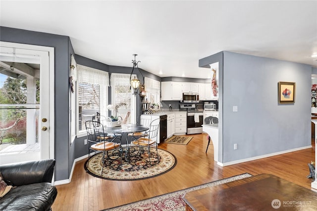 dining room featuring light wood-style flooring and baseboards