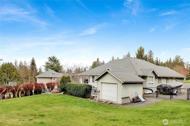 back of property with a tile roof, a yard, fence, and a garage