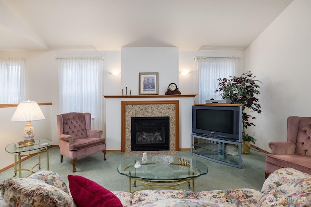 carpeted living room with vaulted ceiling, a fireplace with flush hearth, and baseboards