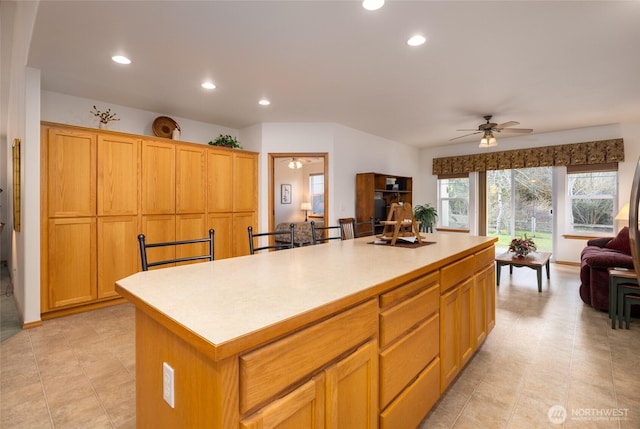 kitchen with a center island, open floor plan, light countertops, recessed lighting, and a ceiling fan