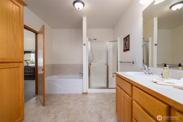 bathroom with vanity, a shower stall, and a bath