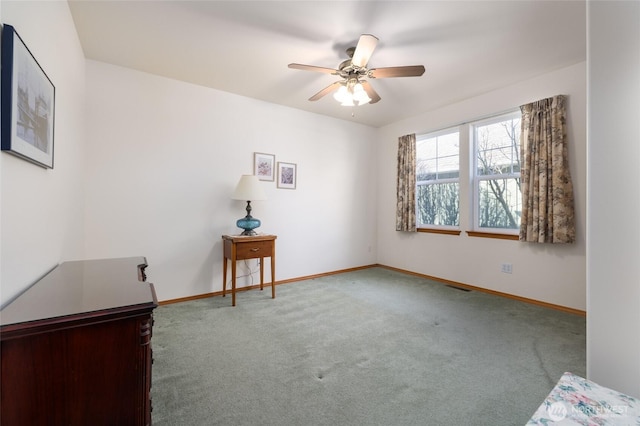 spare room with a ceiling fan, visible vents, carpet, and baseboards