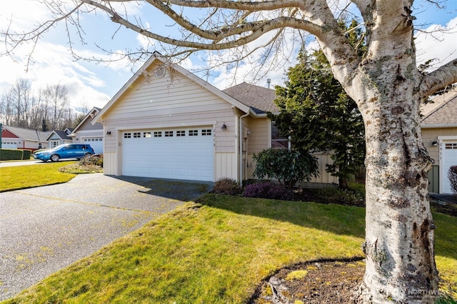 view of front of house featuring a garage, driveway, a front yard, and a shingled roof