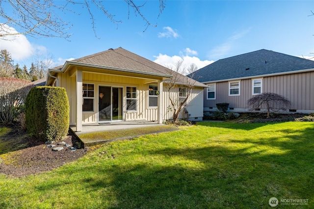 rear view of house with board and batten siding, a patio area, roof with shingles, a lawn, and crawl space