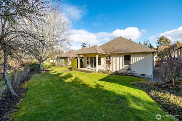 back of house featuring crawl space, a lawn, board and batten siding, and a shingled roof