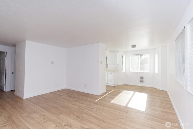 unfurnished room with light wood-type flooring and baseboards