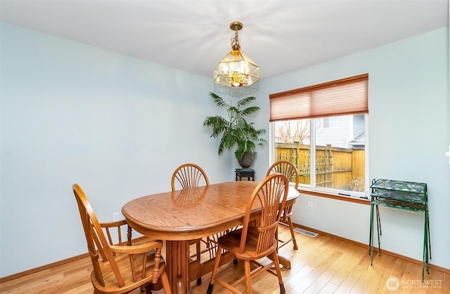 dining space with a chandelier, visible vents, light wood-style flooring, and baseboards