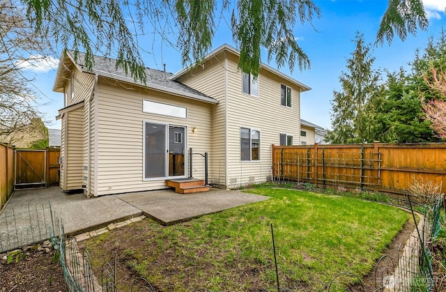 rear view of house featuring a gate, a patio area, a lawn, and a fenced backyard