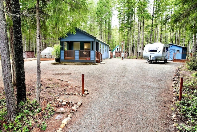 view of front of home with gravel driveway and covered porch