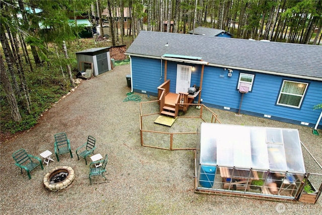 exterior space with crawl space, an outbuilding, and a shingled roof